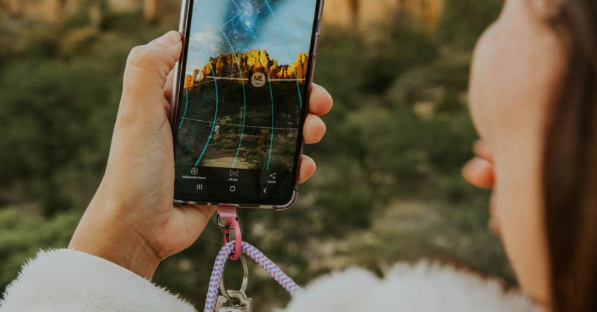 App Monetization - A woman taking a picture of a mountain with her phone