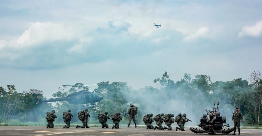Security Training - Unrecognizable soldiers with infantry weapons accomplishing military mission near helicopter